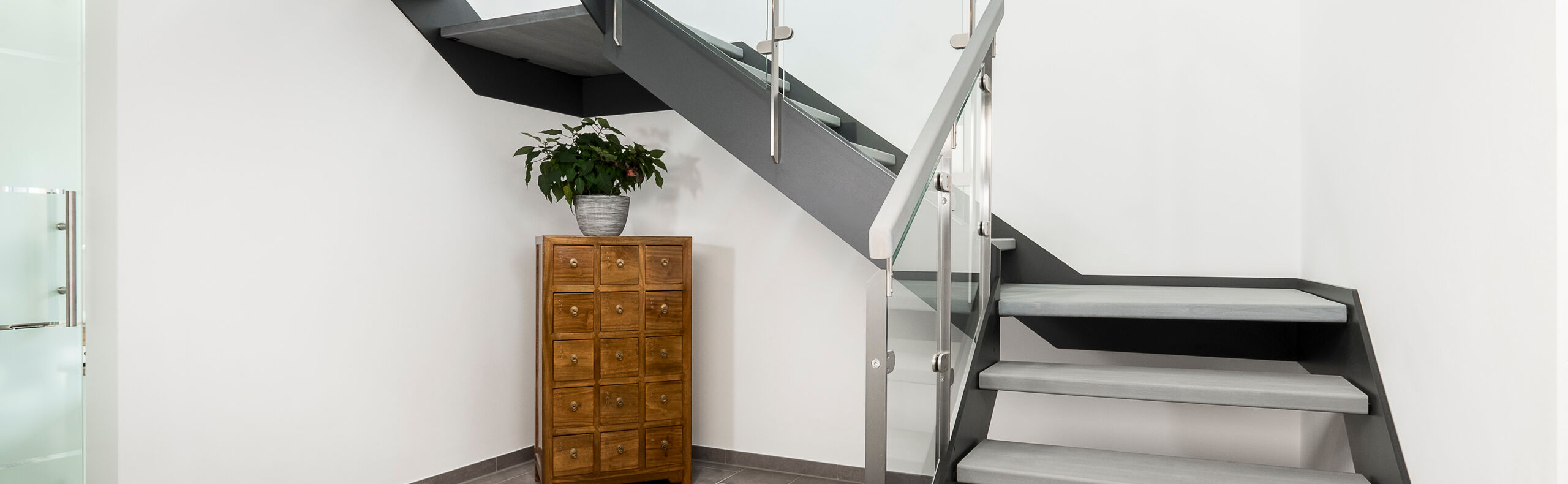 HPL-Treppe mit Glasgeländer, Stufen und Handlauf in der Holzart Buche mosaik mit TBV Echtholz-Öl grau geölt