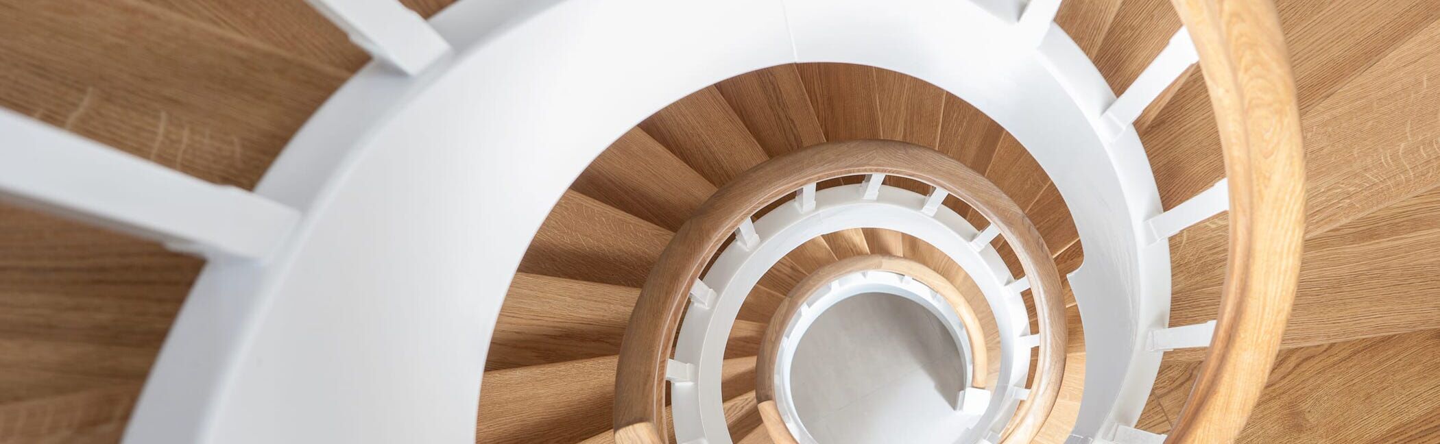 Geschlossene Wangentreppe über 4 Etagen; Wangen, Stäbe und Setzstufen weiß endlackiert; Stufen und Handlauf in der Holzart Eiche geölt. Treppe im Keller von unten mit Raumtrennung, um Raum unterhalb der Treppe zu nutzen.
