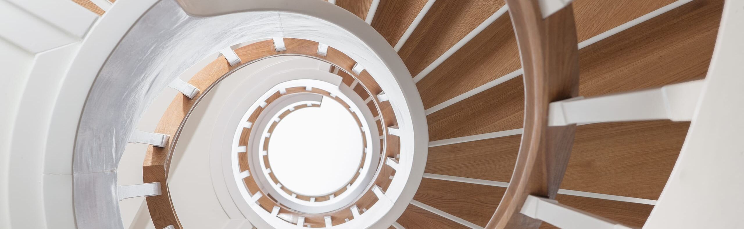 Geschlossene Wangentreppe über 4 Etagen; Wangen, Stäbe und Setzstufen weiß endlackiert; Stufen und Handlauf in der Holzart Eiche geölt. Treppe im Keller von unten mit Raumtrennung, um Raum unterhalb der Treppe zu nutzen.
